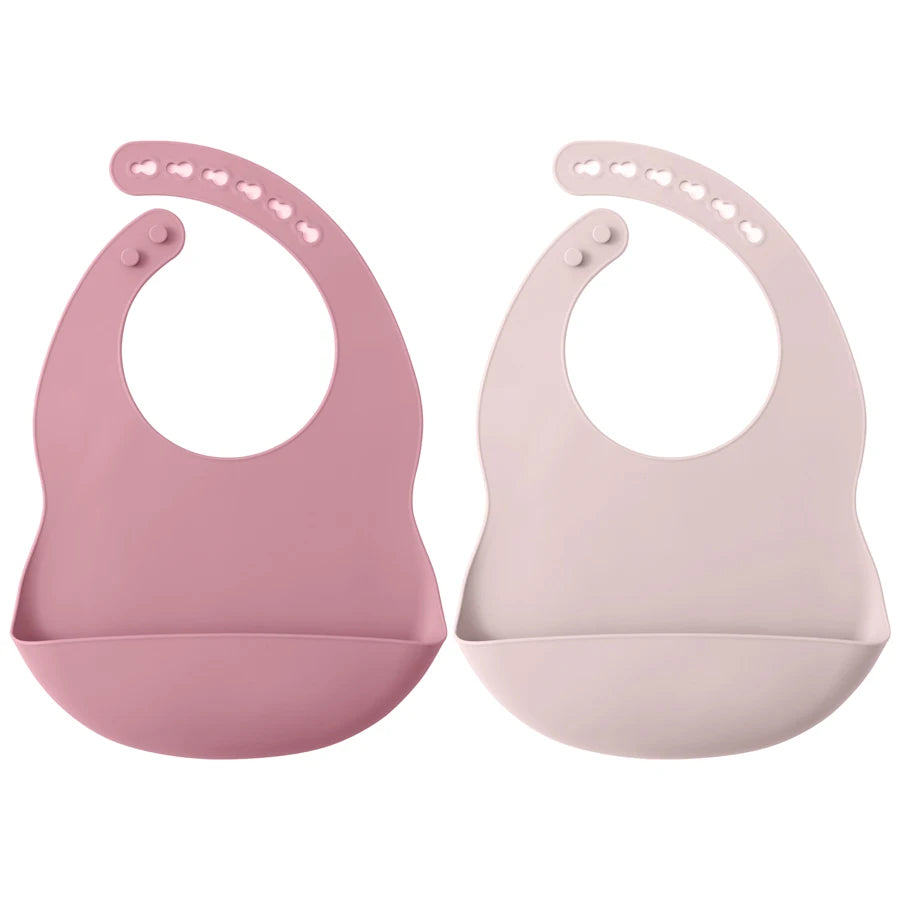 A pair of pink waterproof silicone baby bibs with adjustable necks shown against a white background.