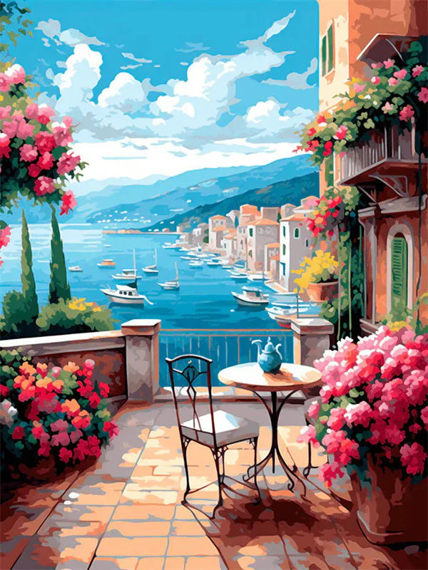 A vibrant painting of a seaside harbor with colorful boats, buildings, and lush pink flowers in a Mediterranean setting.