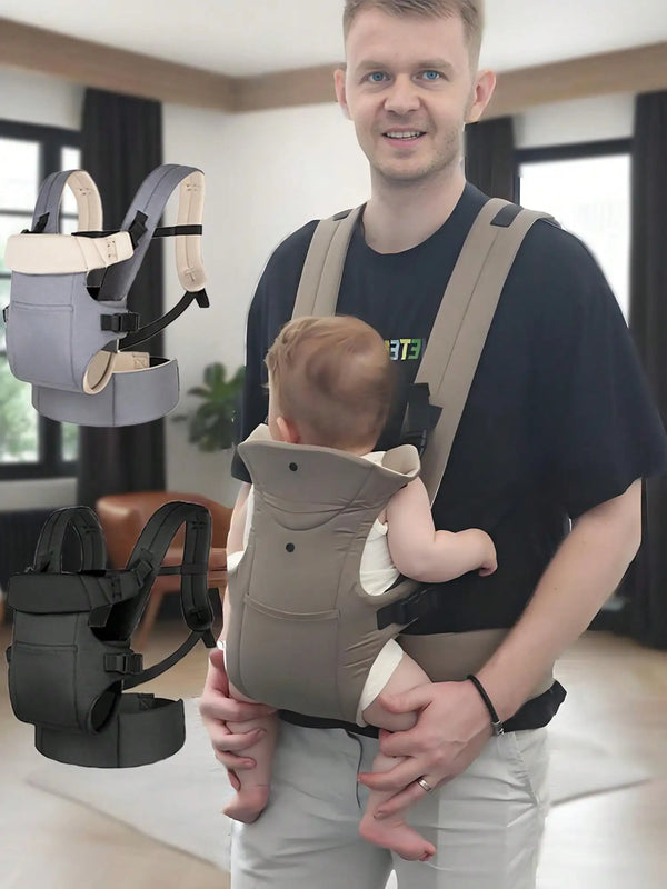 A man wearing a beige adjustable front and back baby carrier while holding a baby.