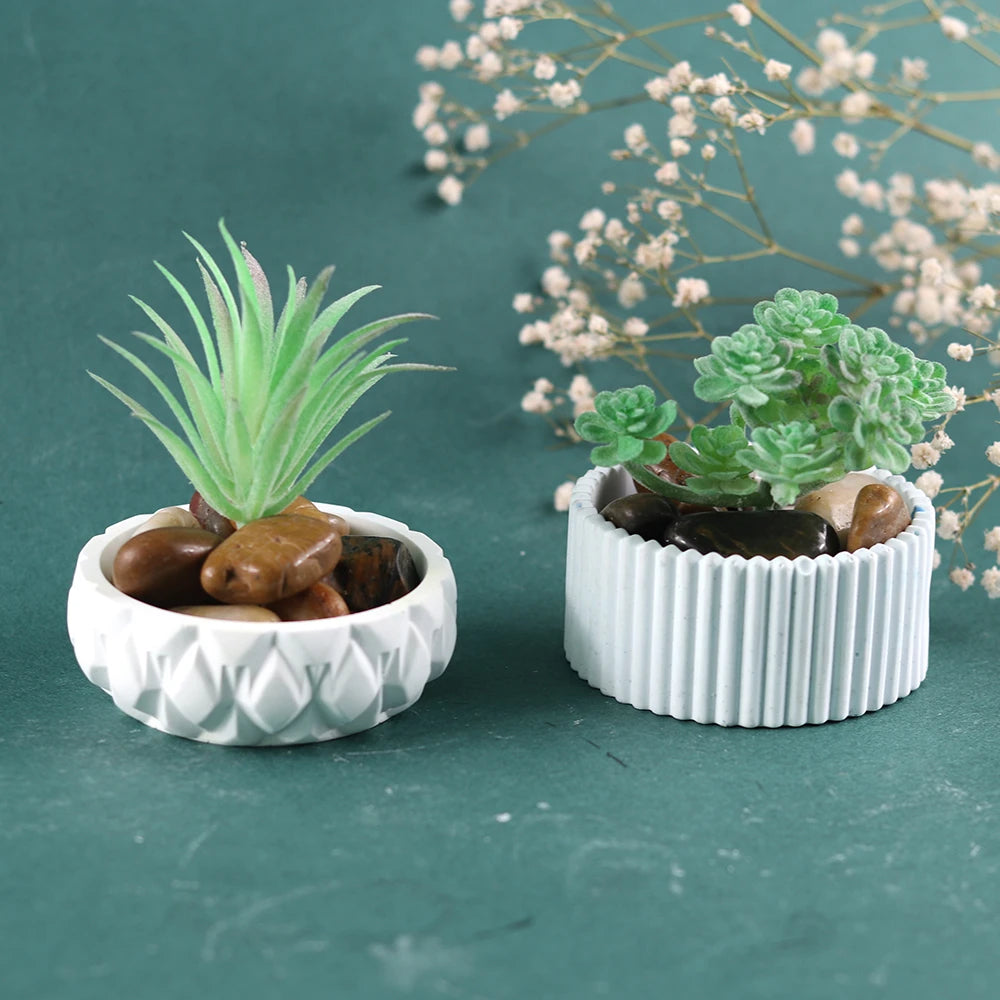A flexible silicone mold for concrete, plaster, and resin vases and planters, showing green succulents in white ceramic pots.