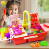 A child is playing with a red electric kitchen sink toy set featuring running water and play food items.