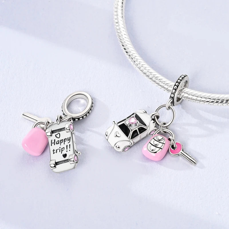Sterling silver charm bead pendant featuring a car, key, and pink bead on a silver chain.
