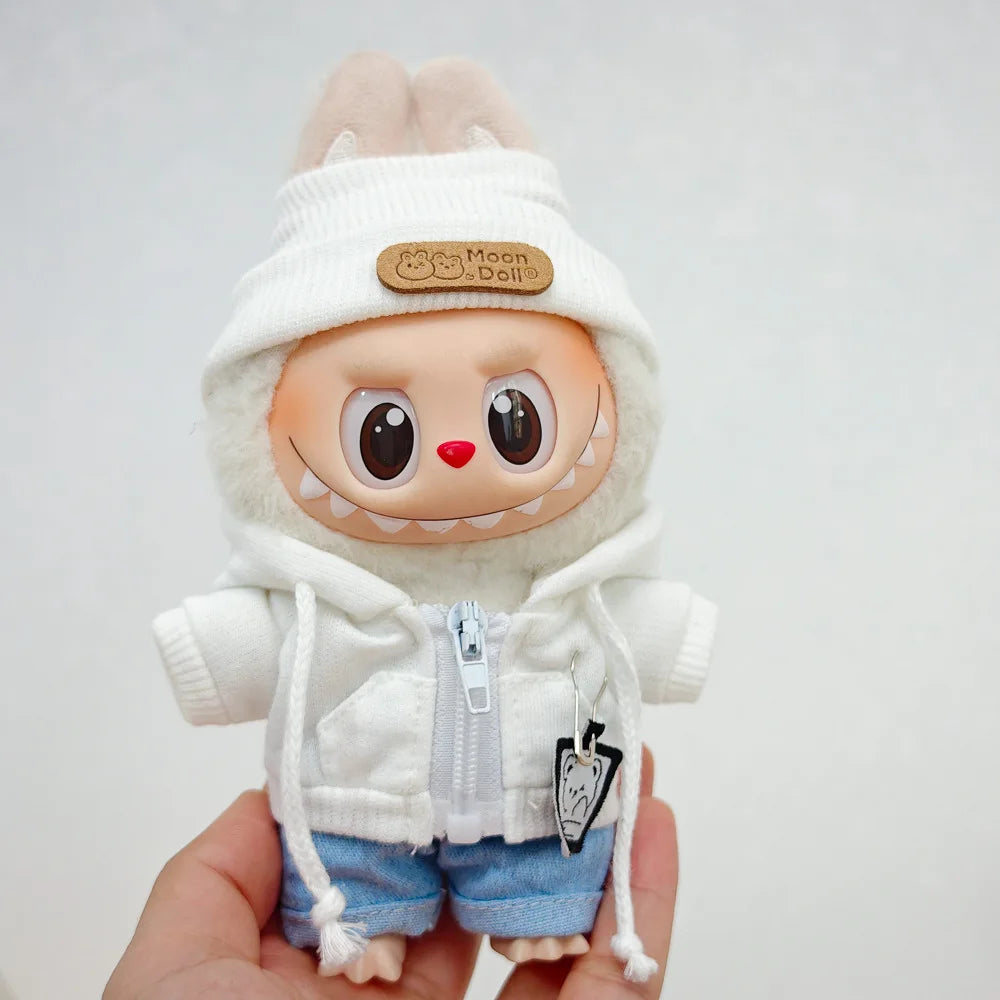 A plush doll wearing a white hoodie and blue pants with a moon-themed tag.