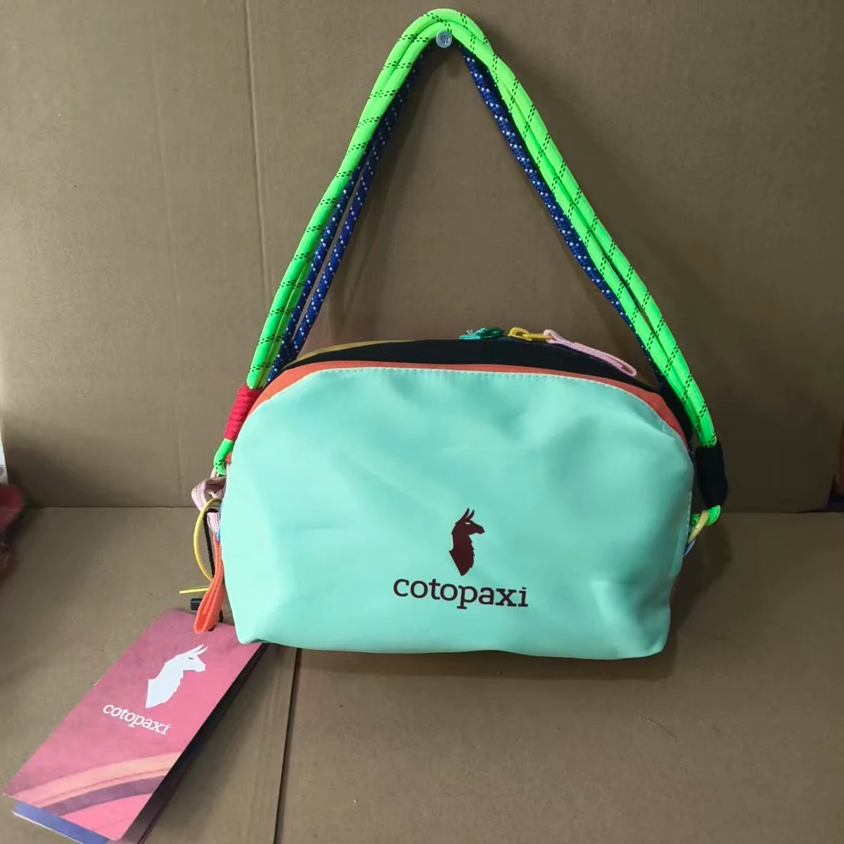 Light blue alpaca themed travel storage bag with a green and purple strap