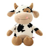 A white and black plush cow stuffed animal with brown accents, designed as a cuddle pillow.