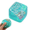 A translucent teal squishy butter stick fidget toy with silver stars and sea shells inside, held by a hand.