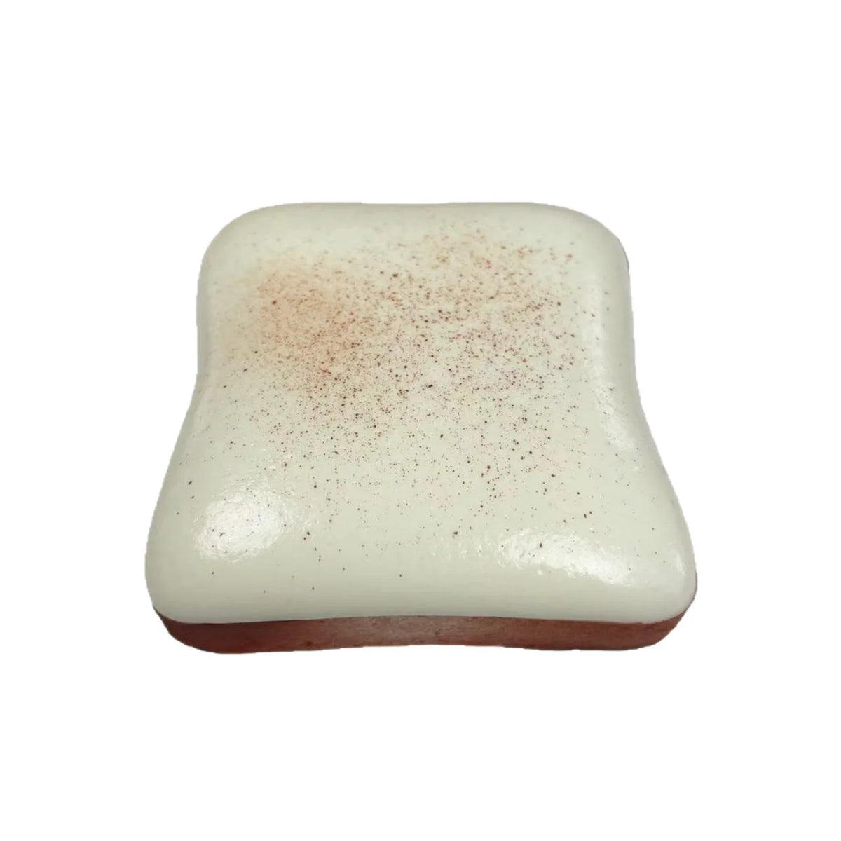 A square, white squishy stress relief toy with a reddish-brown dusting on top.