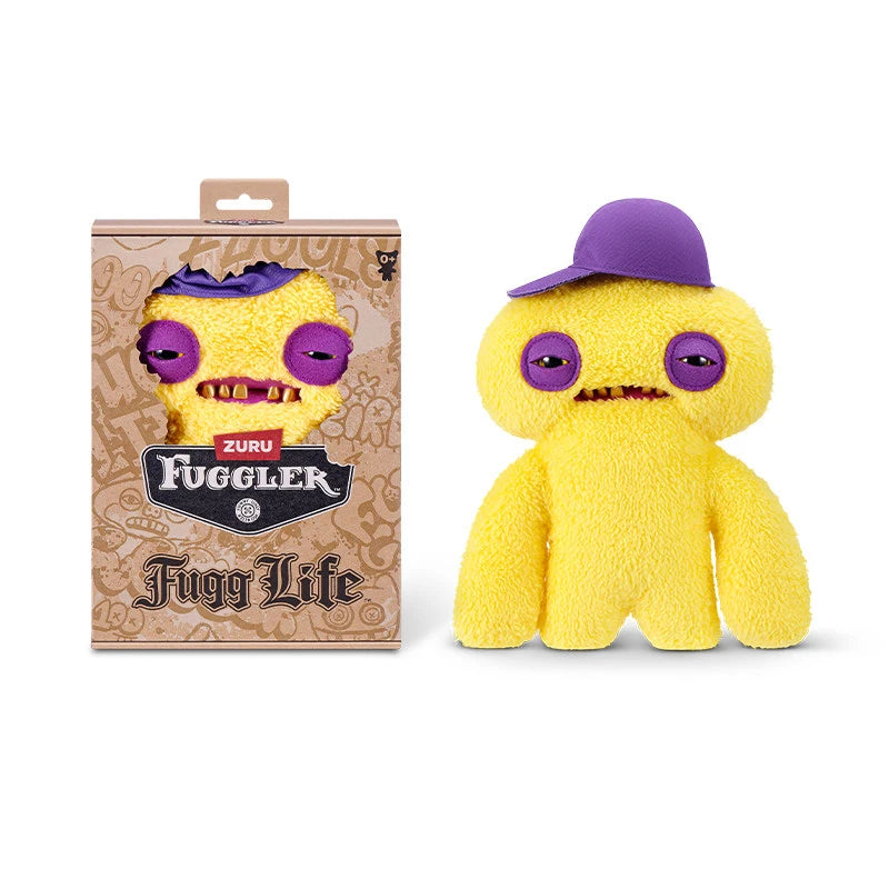 A yellow Fuggler plush toy monster with purple eyes and a purple hat is shown next to its packaging.