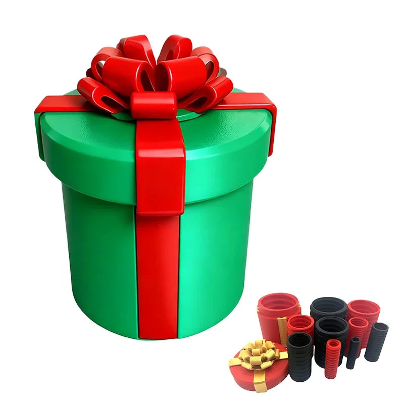 A green gift box tied with a red ribbon, next to several small red and black nested screw boxes.