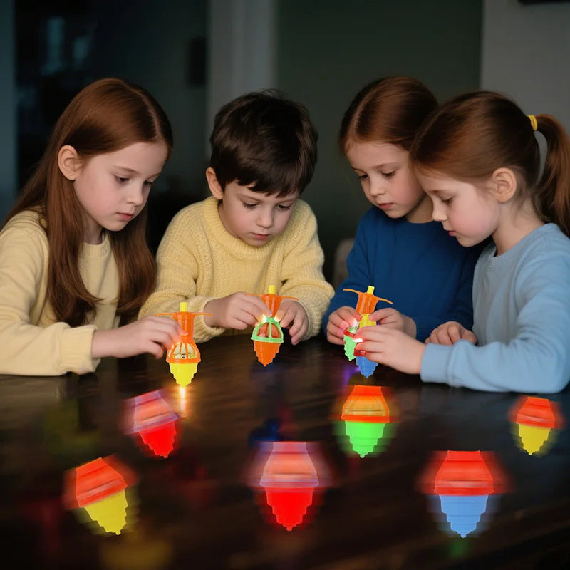 Four children are playing with glow-in-the-dark spinning tops on a dark table.