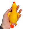 A hand is holding a bright yellow and orange jumbo squishy duck stress ball fidget toy.