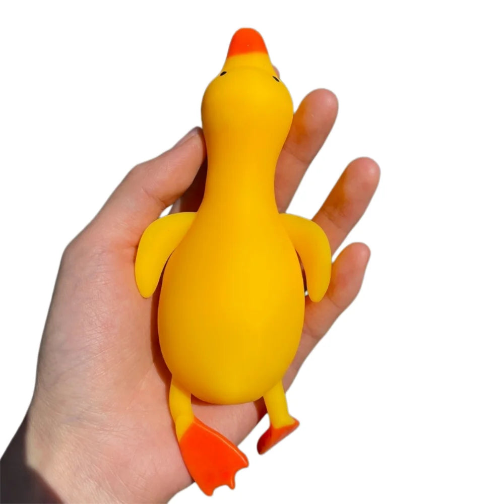 A hand is holding a bright yellow and orange jumbo squishy duck stress ball fidget toy.