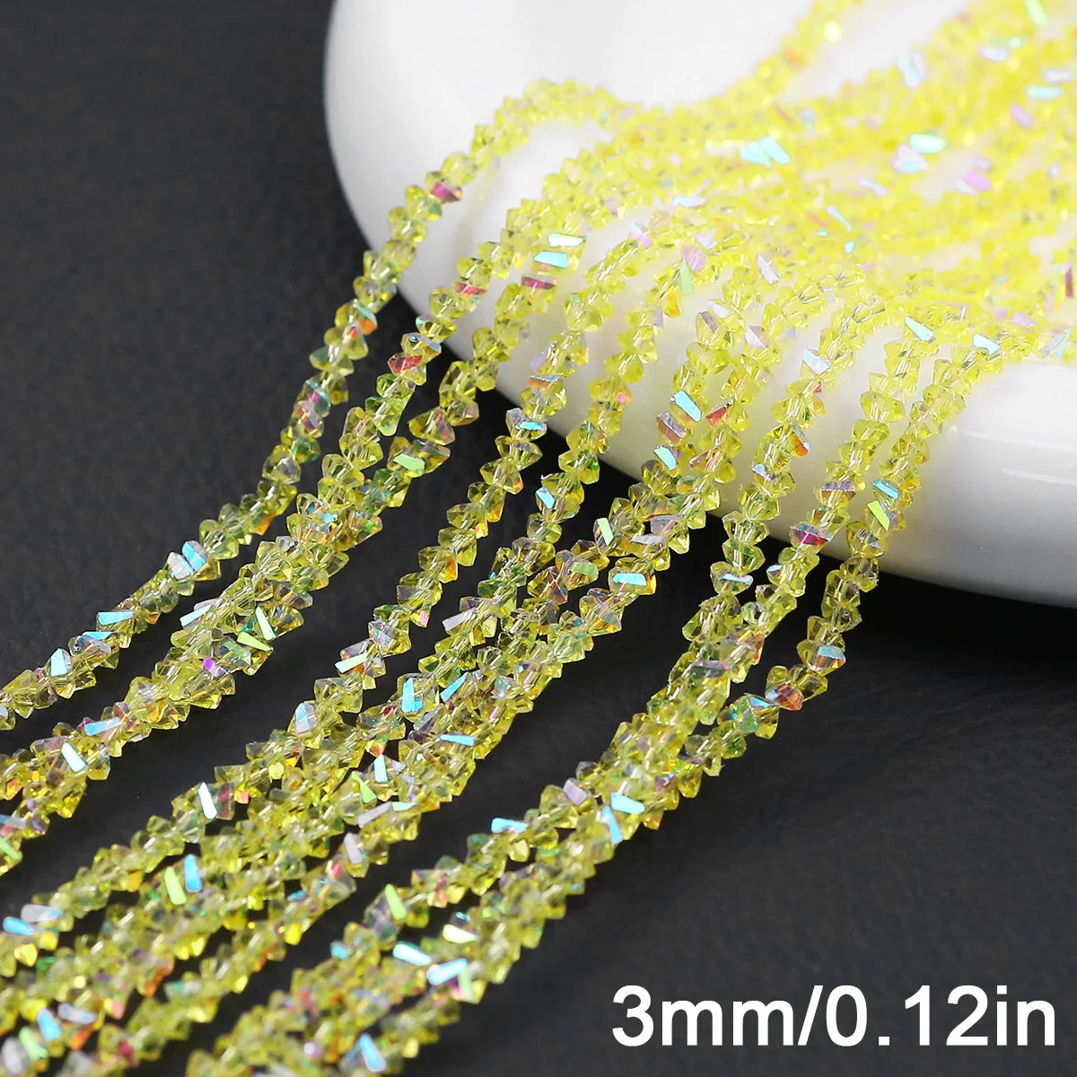Yellow crystal triangle beads strung together on a white surface