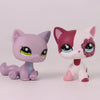 A pair of Shorthair Cat Bobble Head figurines, one purple and one pink with white markings.