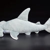 A light gray super soft hammerhead shark plush toy lying on a dark surface.