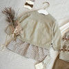 A light beige knit sweater and matching pants set for a toddler, displayed on a light background.