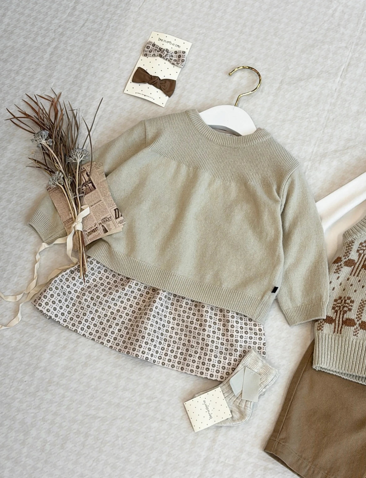 A light beige knit sweater and matching pants set for a toddler, displayed on a light background.