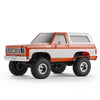 A 1:24 scale Chevrolet K5 Blazer RC crawler truck in orange and white colors.