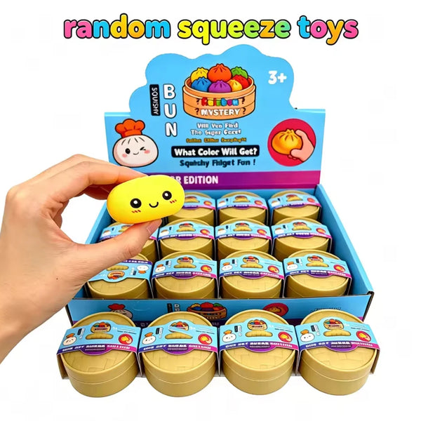 A hand holds a box of colorful simulated steamed bun squishy toys, including various colored buns.