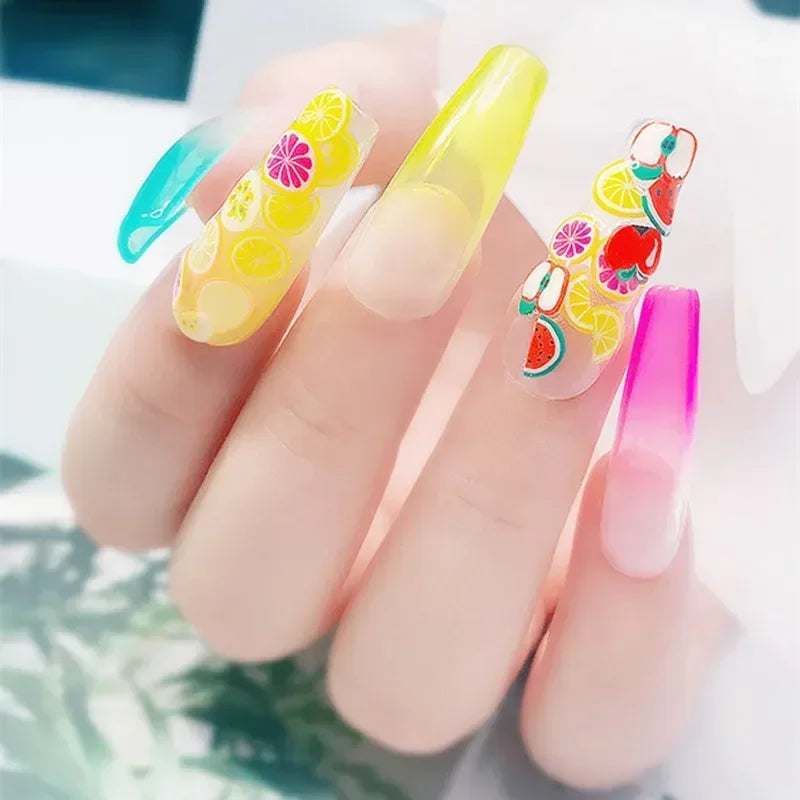 A hand holds several polymer clay flower charms in various bright colors and designs for DIY crafts.