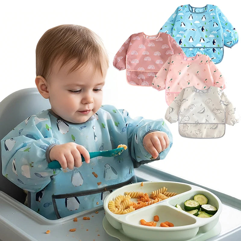A baby is eating food from a bib while surrounded by various full-sleeve waterproof baby bibs.