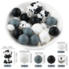 A white bowl filled with various black and white silicone beads, including a dog figure, for DIY jewelry making.