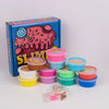 A box of butter slime with cake decorations, various colored slime containers, and loose glitter.