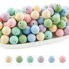 A collection of round silicone beads in various pastel colors including pink, green, yellow, and blue.