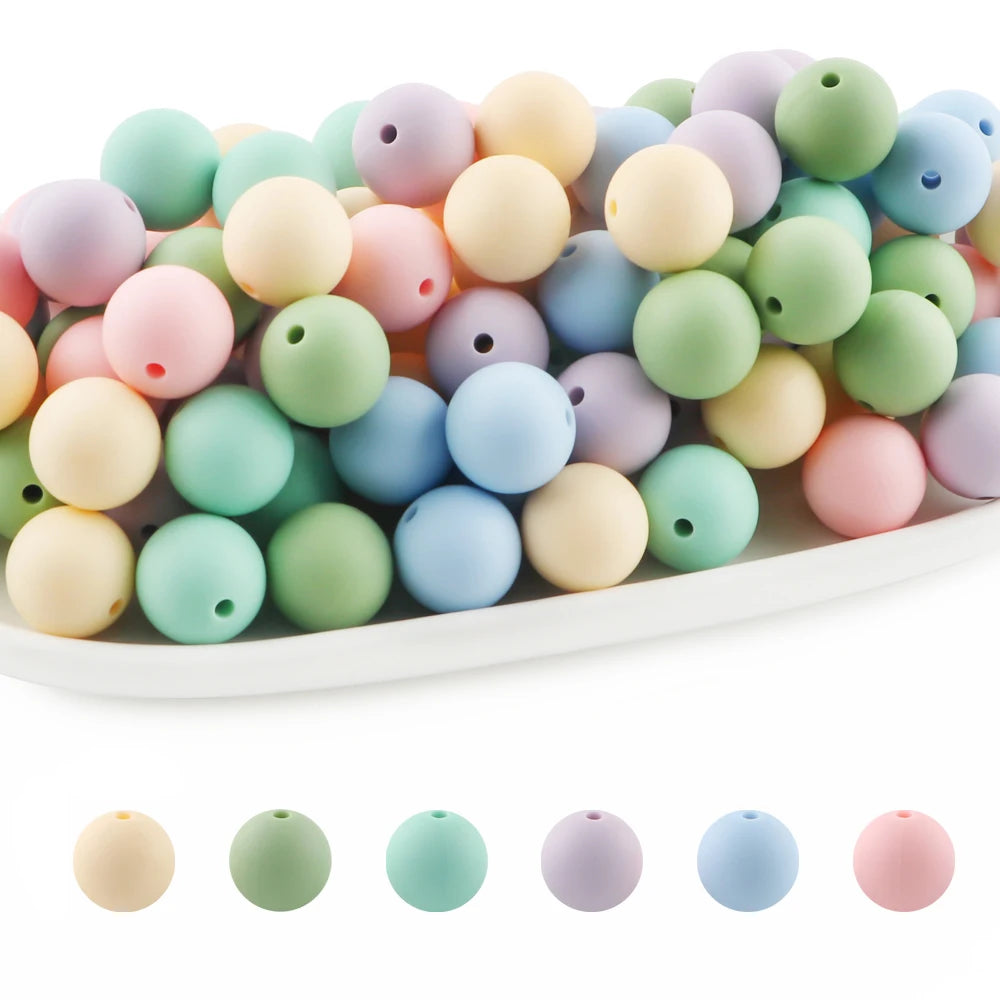 A collection of round silicone beads in various pastel colors including pink, green, yellow, and blue.