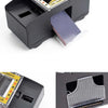 A black automatic card shuffler device with a slot for cards and a card outlet.