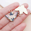 Gold-toned butterfly drop charm and a leaf-shaped gold-toned charm displayed on a hand.