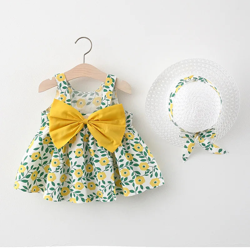 A yellow floral print baby girl summer dress and sunhat set with bow details displayed on a hanger.
