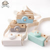 A set of wooden camera teether toys in light wood and pastel blue colors for baby teething