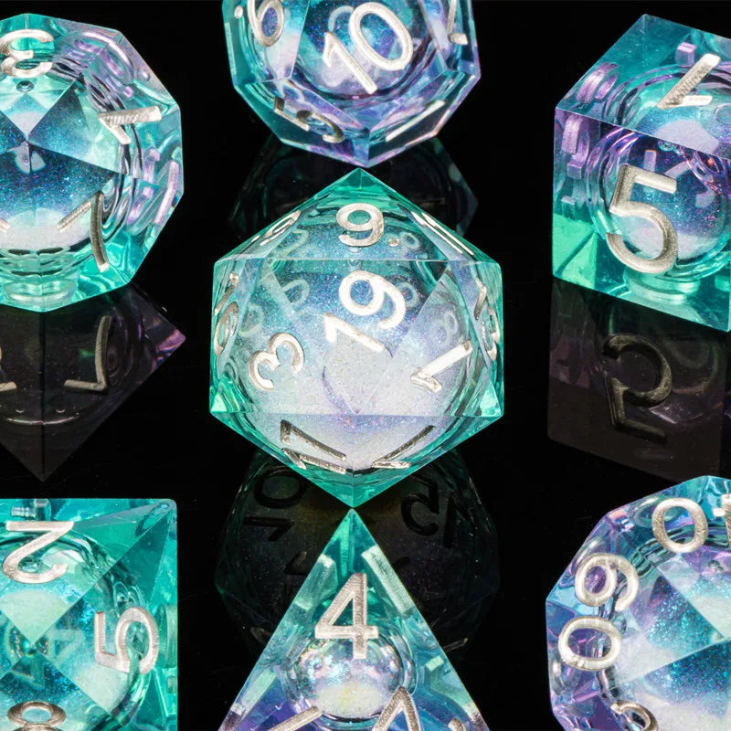 A collection of iridescent blue and teal polyhedral dice, including a d10, d20, and d4, displayed on a reflective surface.