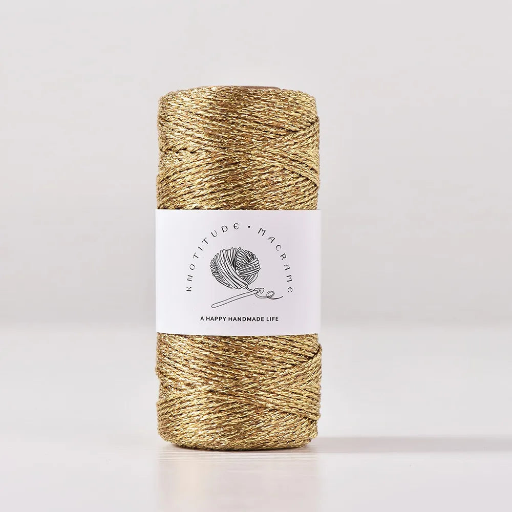 A spool of metallic gold yarn for knitting and crochet thread