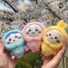 Three pastel-colored Usagi Hachiware plush keychains in blue, pink, and yellow are held by a hand.