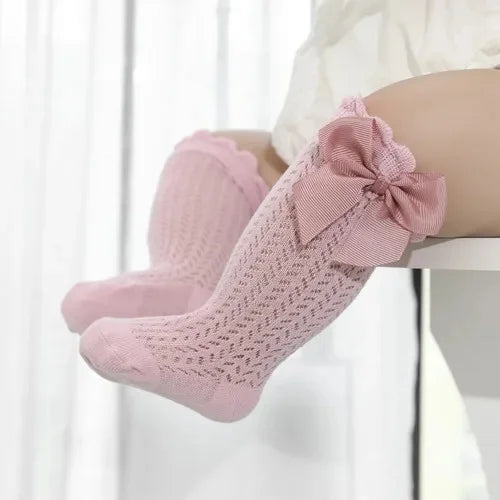 Pink lace knee socks for a baby girl with a decorative bow