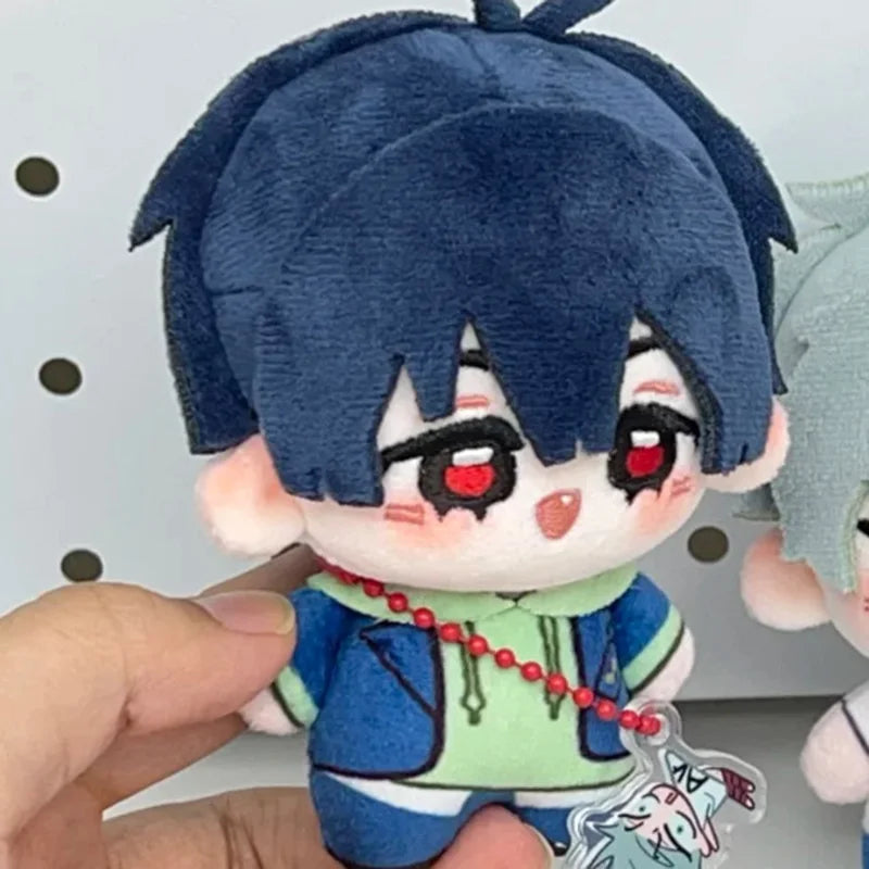 A chibi plush keychain of a blue-haired character with red eyes wearing a blue jacket and green accents.