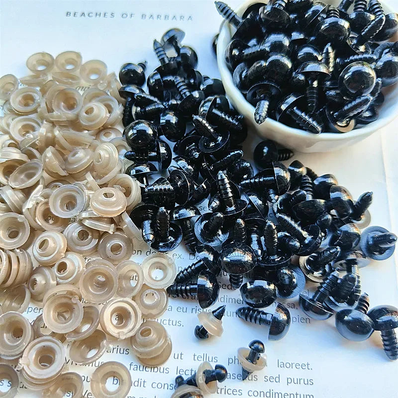 A collection of black and clear plastic safety eyes for crafting, including round and conical shapes.