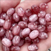 A hand holds a pack of ten pink and reddish resin starry sky cat's eye beads for jewelry making.