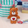 A fluffy orange Care Bears plush toy with a red heart on its chest, hanging from a pink loop.