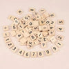 A scattered collection of wooden alphabet letter tiles numbered 0 through 12 arranged in a circular pattern.