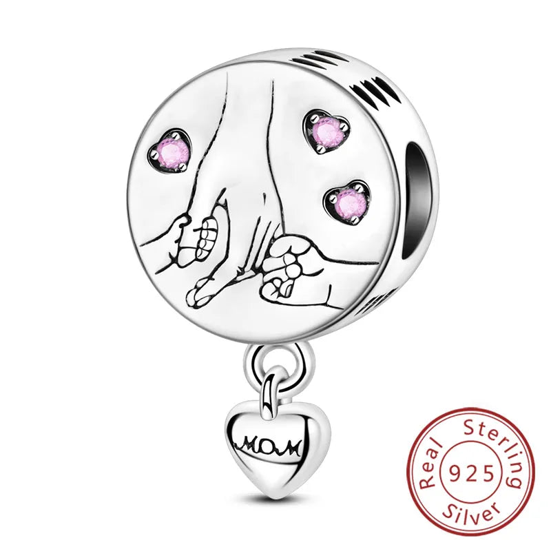 A sterling silver charm bead featuring a handprint design with pink heart accents.
