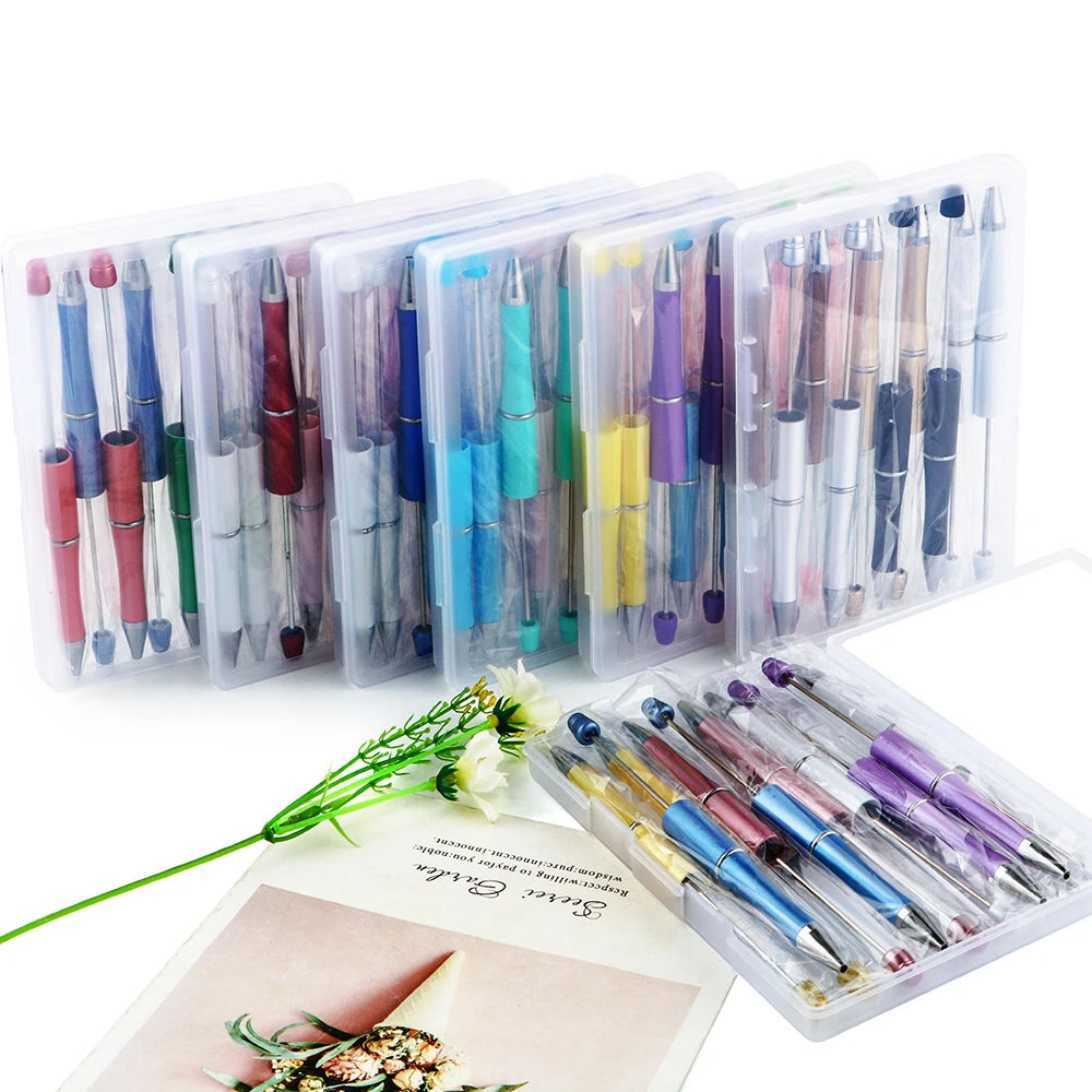 A collection of DIY beaded ballpoint pen kits in various colors and designs displayed in clear plastic packaging.