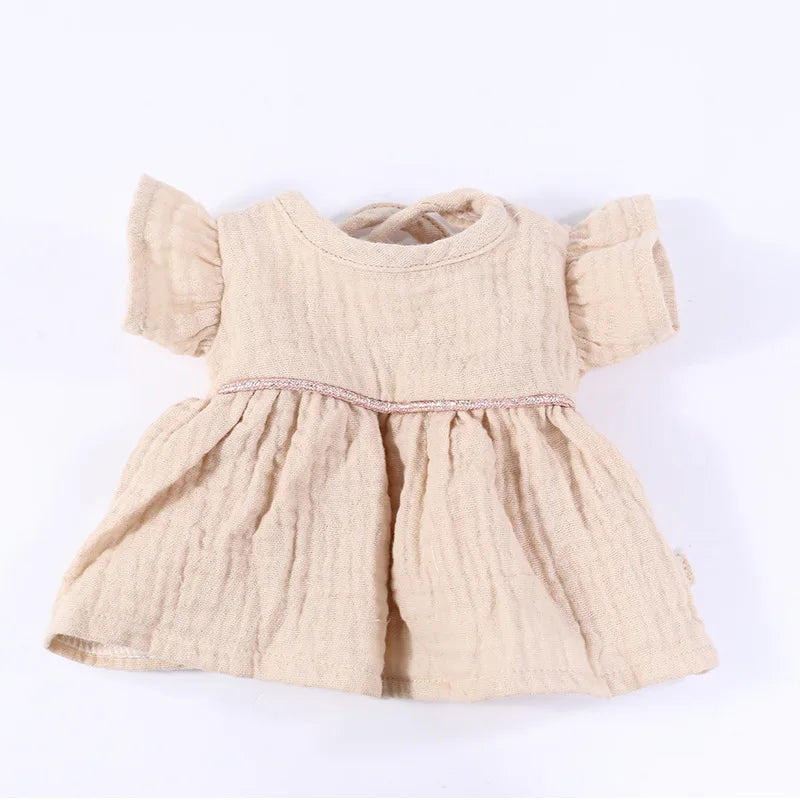 A light beige three-piece doll outfit set for a baby doll featuring a top and skirt.