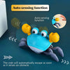 A blue and yellow interactive music crab toy demonstrating its auto-sensing function.