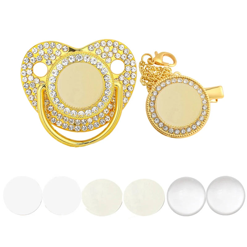 A set of gold-toned baby pacifiers and clips decorated with sparkling rhinestones.