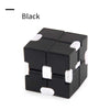 A black fidget cube with white accents shown from above.