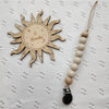 Wooden bead pacifier clip featuring a sun design and six months marking