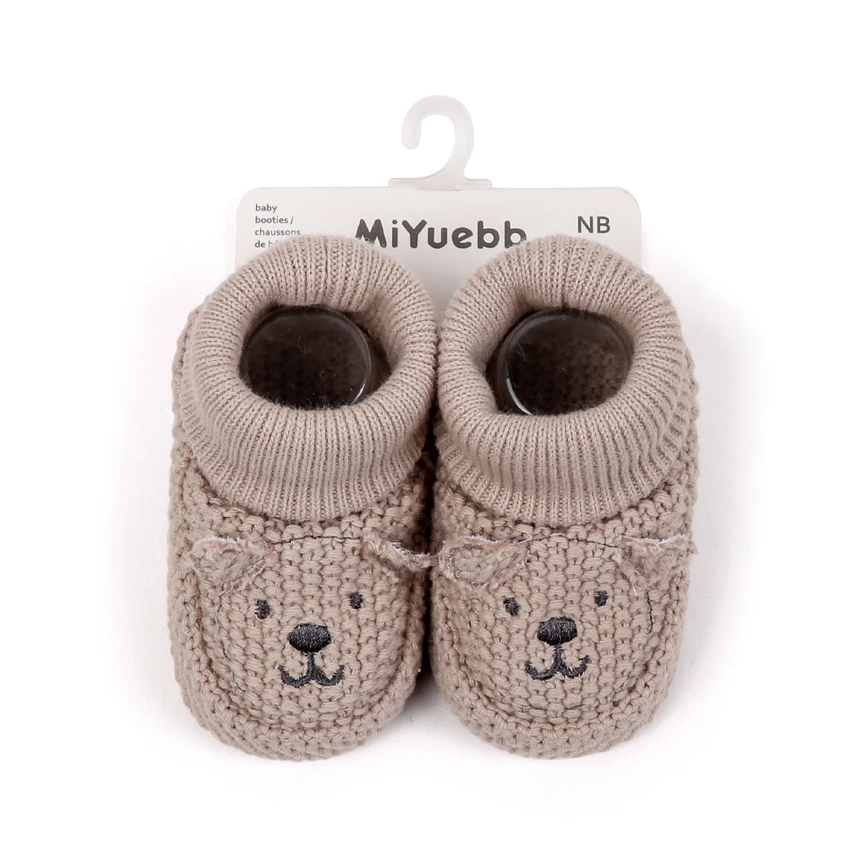 Pair of handmade knitted baby booties resembling a bear face in a light beige color
